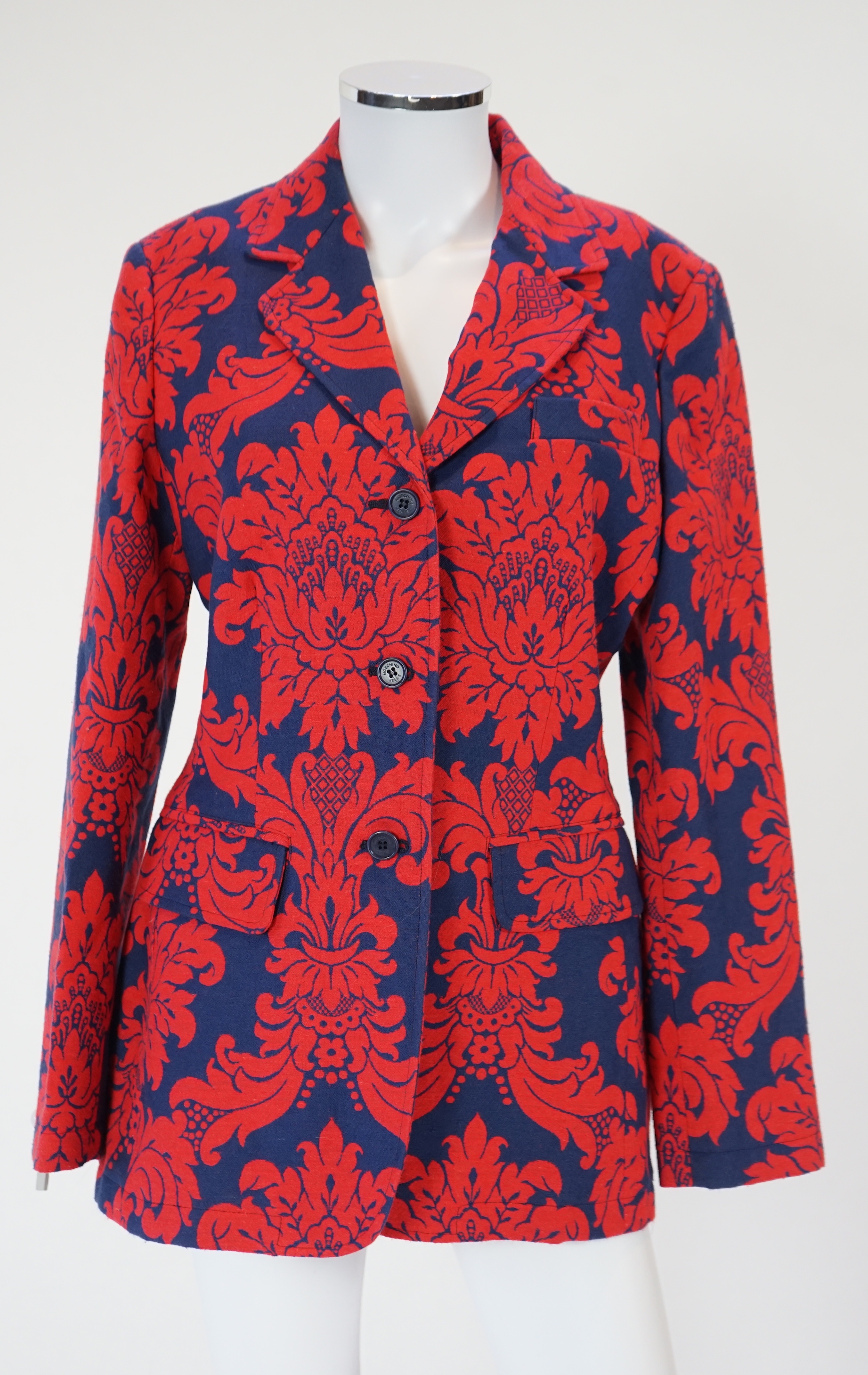 A Moschino lady's long blue and red jacket, a cream cotton embellished blazer and a cotton pair of floral trousers, blue and red jacket size 14, cream blazer size 12, trousers size: 10